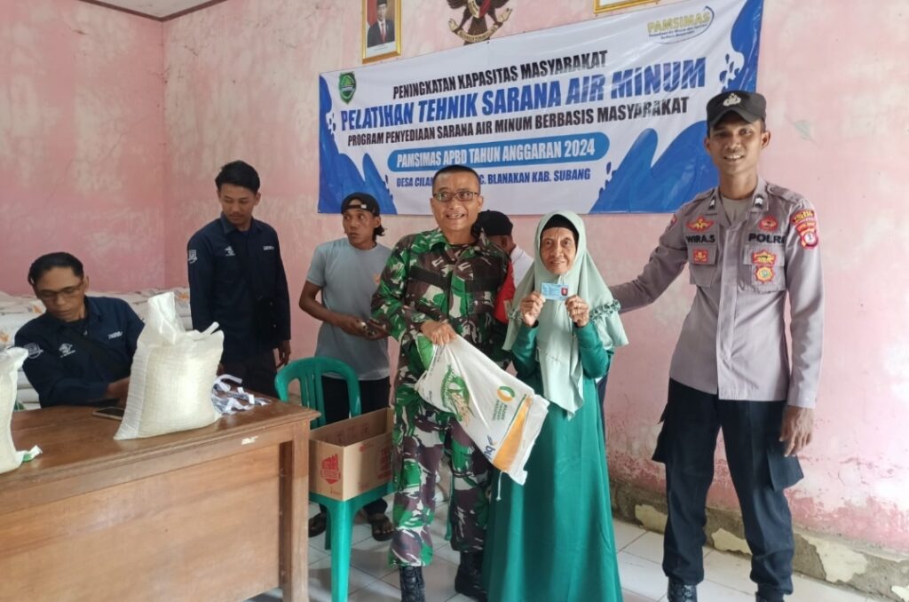 Bhabinkamtibmas Desa Cilamaya Hilir Briptu Wira bergabung dengan Babinsa Desa Cilamaya Hilir Sertu Asep Susanto Dalam Pengamanan Penyaluran Bansos.