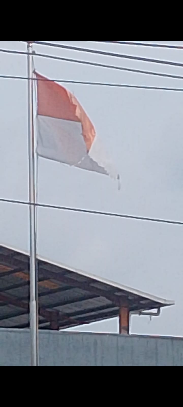 Bendera Merah Putih Berkibar Di Pelataran Perusahaan MERCEDES BENS dalam Keadakan Robek dan kotor