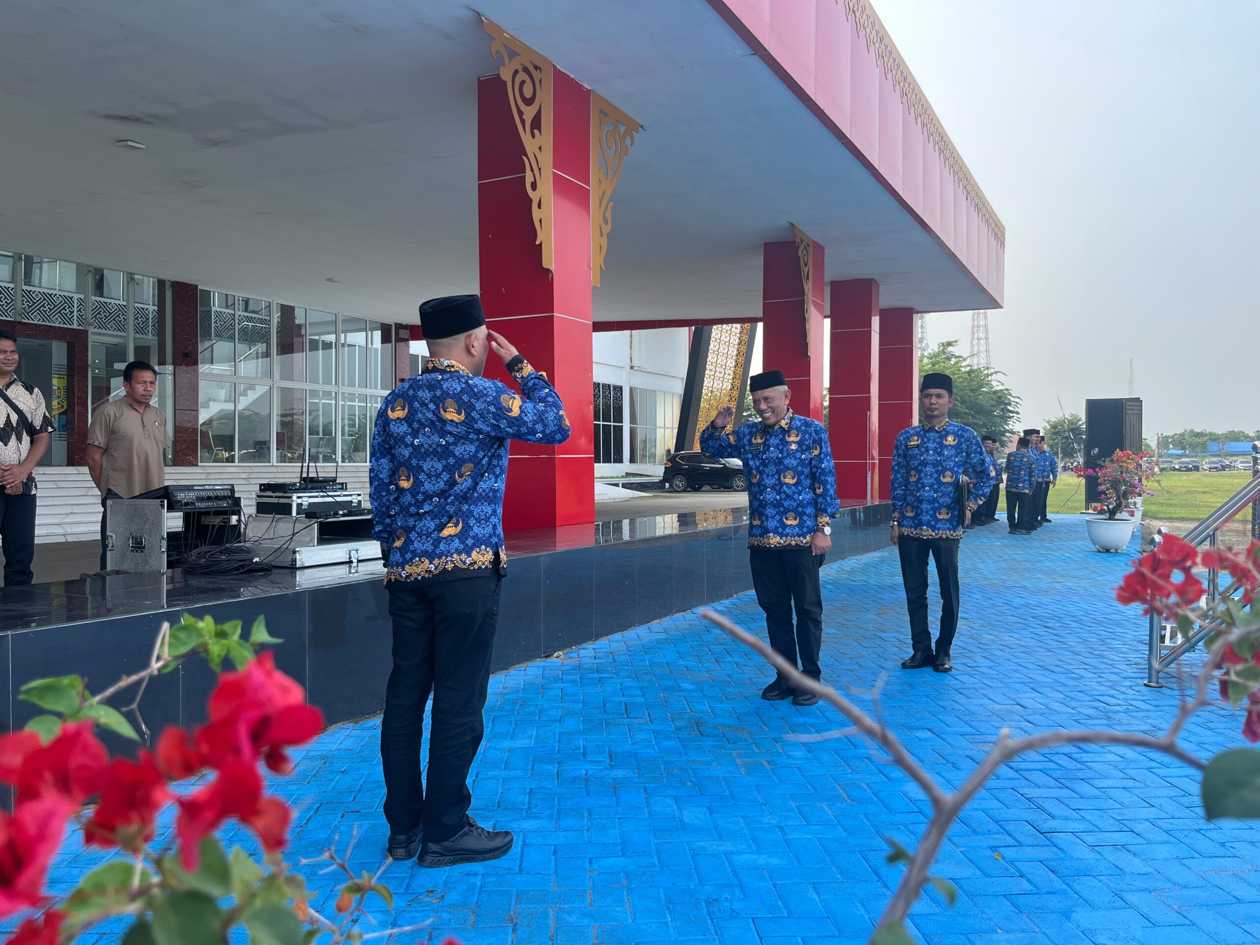 Pemkab Batu Bara Gelar Upacara HKN, ASN Diingatkan Perkuat Disiplin dan Pelayanan Publik  BATU BARA — Pemerintah Kabupaten Batu Bara kembali menggelar Upacara Hari Kesadaran Nasional (HKN) sebagai momentum untuk memperkuat kedisiplinan, integritas, dan tanggung jawab aparatur sipil negara (ASN) dalam memberikan pelayanan terbaik kepada masyarakat.  Upacara yang berlangsung di Halaman Kantor Bupati Batu Bara, Kecamatan Lima Puluh, Kamis (17/9/2026), diikuti jajaran ASN di lingkungan Pemerintah Kabupaten Batu Bara.  Bupati Batu Bara Dr. H. Baharuddin Siagian, S.H., M.Si., C.L.A., diwakili Pj. Sekretaris Daerah (Sekda) Batu Bara Rusian Heri, yang memimpin jalannya upacara sekaligus menyampaikan amanat Bupati.  Dalam amanatnya, Rusian Heri menegaskan bahwa Hari Kesadaran Nasional yang diperingati setiap tanggal 17 bukan sekadar agenda seremonial pemerintahan. Momentum tersebut menjadi pengingat bagi seluruh ASN untuk terus meningkatkan kesadaran terhadap tugas, tanggung jawab, serta peran sebagai abdi negara sekaligus pelayan masyarakat.  “Peringatan Hari Kesadaran Nasional hendaknya menjadi momentum untuk memperkuat kesadaran, meningkatkan kualitas kinerja, serta menumbuhkan semangat dan tanggung jawab dalam menjalankan tugas dan kewajiban sebagai abdi negara dan pelayan masyarakat,” demikian inti amanat yang disampaikan.  Ia juga mengingatkan seluruh ASN agar senantiasa menjaga disiplin dan profesionalisme dalam melaksanakan tugas. Pelayanan kepada masyarakat, kata dia, harus terus diarahkan agar semakin optimal, responsif, dan berkualitas.  Pesan tersebut menjadi penting di tengah tuntutan masyarakat terhadap kinerja pemerintah yang semakin terbuka dan membutuhkan pelayanan yang cepat serta tepat.  Melalui Upacara HKN, jajaran Pemerintah Kabupaten Batu Bara diharapkan tidak hanya menjalankan rutinitas apel bulanan, tetapi juga mampu menerapkan nilai-nilai kedisiplinan dan integritas dalam pekerjaan sehari-hari.  Seluruh ASN juga didorong untuk memperkuat sinergi antarperangkat daerah sehingga program pemerintahan dan pembangunan dapat berjalan secara efektif serta memberikan manfaat nyata bagi masyarakat Batu Bara.  Dengan semangat Hari Kesadaran Nasional, Pemkab Batu Bara kembali mengingatkan bahwa kualitas pemerintahan tidak hanya diukur dari program yang dibuat, tetapi juga dari bagaimana aparatur menjalankan tugas dan memberikan pelayanan kepada masyarakat.